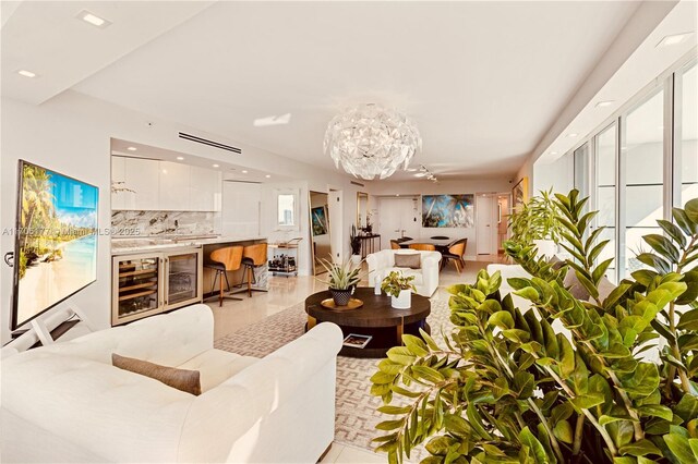 living room with a wealth of natural light, light tile patterned floors, and an inviting chandelier