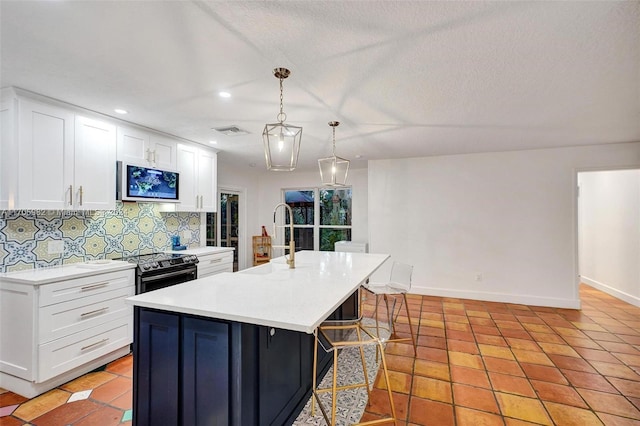 kitchen with a center island with sink, white cabinets, black range with electric stovetop, tasteful backsplash, and decorative light fixtures