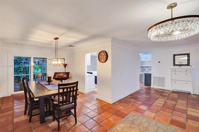 tiled dining area with ornamental molding and a textured ceiling