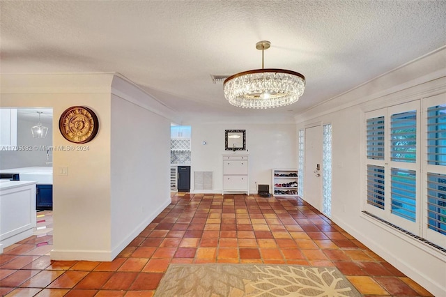 corridor featuring a textured ceiling, an inviting chandelier, and a wealth of natural light