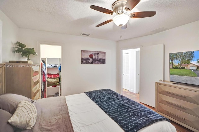 bedroom with a textured ceiling, a closet, and ceiling fan