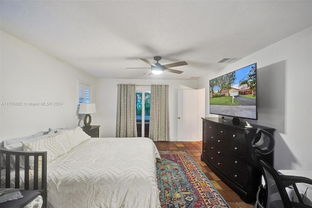 tiled bedroom featuring ceiling fan and a textured ceiling