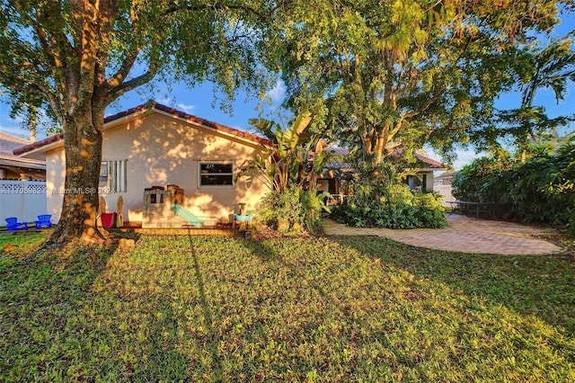 back of property featuring a patio area and a yard