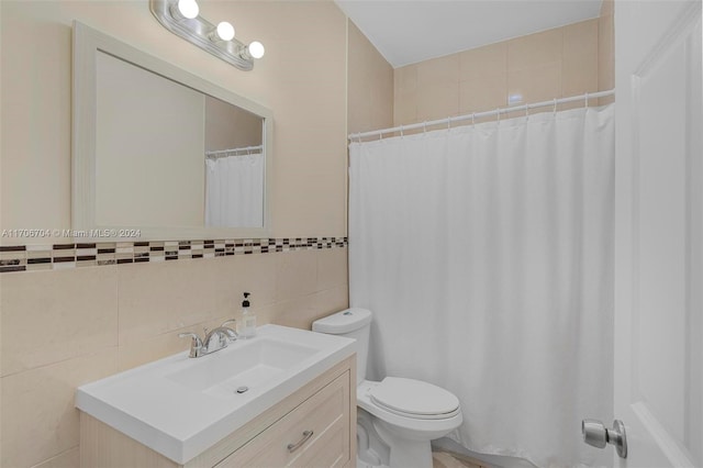 bathroom featuring vanity, toilet, and tile walls