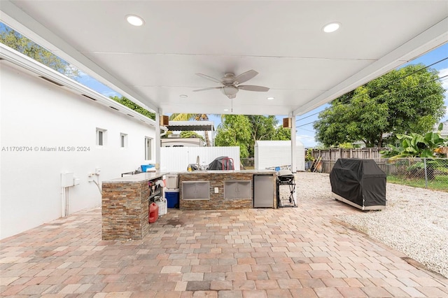 view of patio / terrace with a bar, area for grilling, and ceiling fan