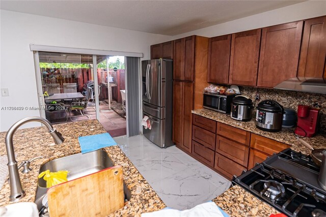 17921 SW 140th Ct Unit 17921, Miami, FL 33177 - kitchen with stainless steel appliances, light marble finish floors, backsplash, and brown cabinetry