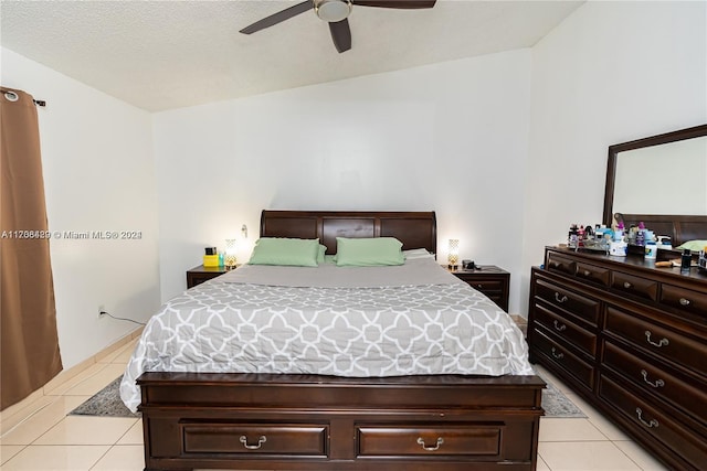 tiled bedroom with ceiling fan, a textured ceiling, and vaulted ceiling