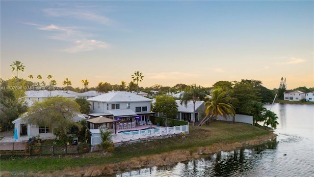 back house at dusk featuring a water view