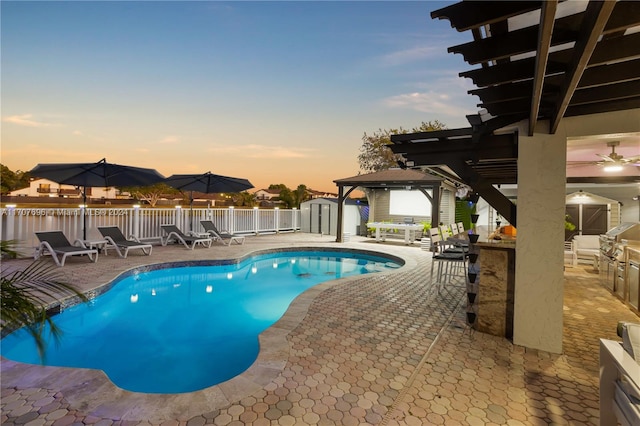 pool at dusk featuring a gazebo, area for grilling, and a patio area