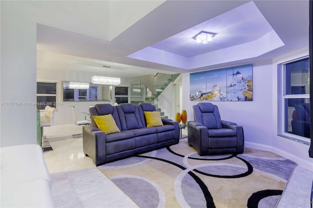 living room featuring a notable chandelier and a tray ceiling