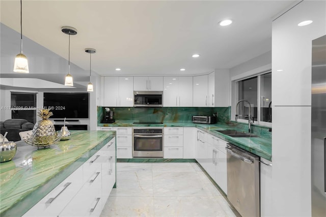 kitchen with sink, white cabinets, pendant lighting, and appliances with stainless steel finishes