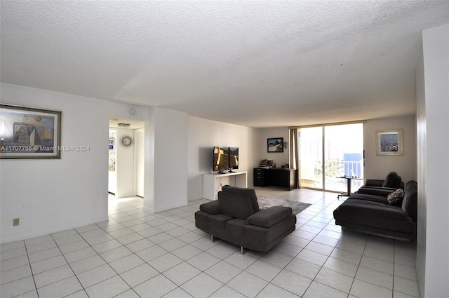 living room with a textured ceiling and light tile patterned flooring