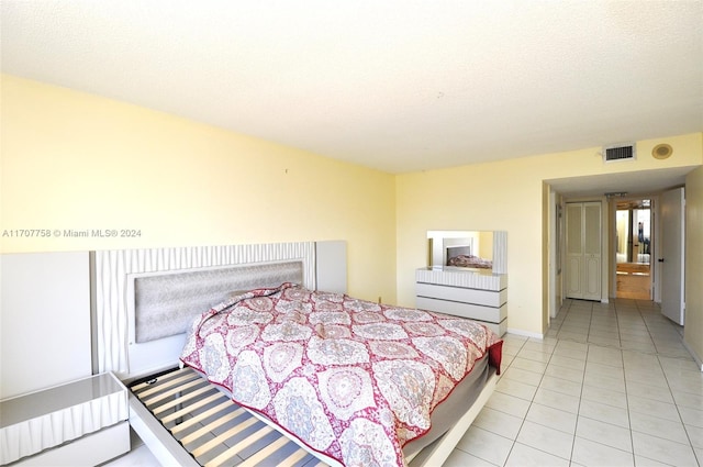 bedroom featuring light tile patterned floors and a textured ceiling