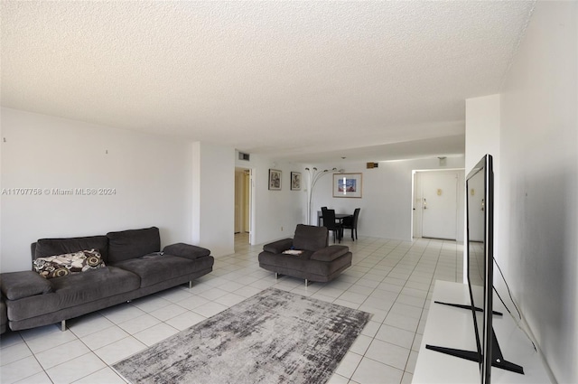 tiled living room featuring a textured ceiling