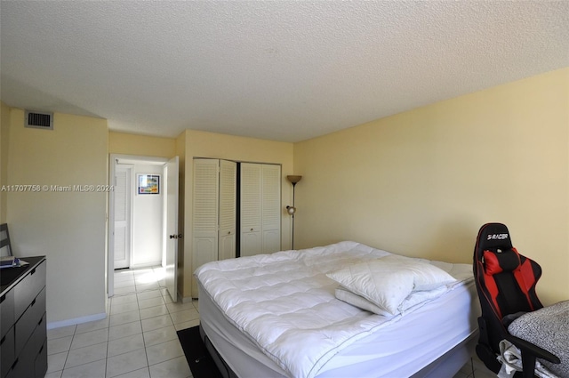 tiled bedroom with a closet and a textured ceiling