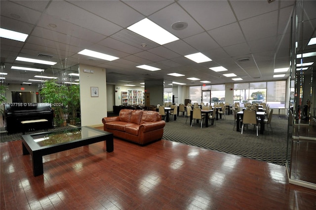 living room featuring a drop ceiling and wood-type flooring