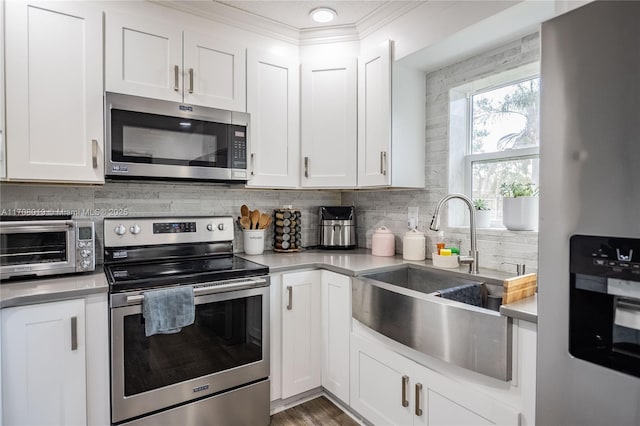 kitchen featuring white cabinetry, sink, backsplash, and stainless steel appliances