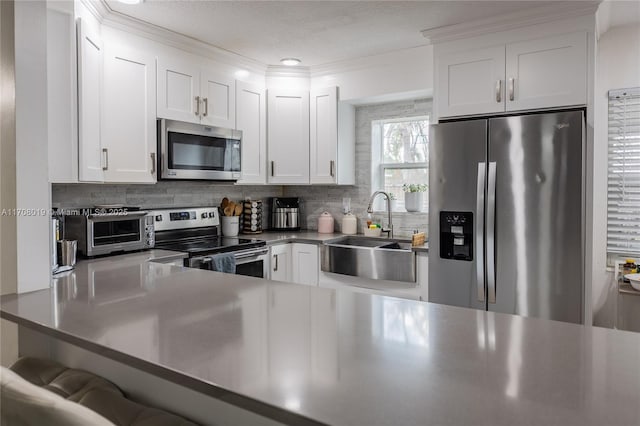 kitchen with white cabinetry, stainless steel appliances, and tasteful backsplash