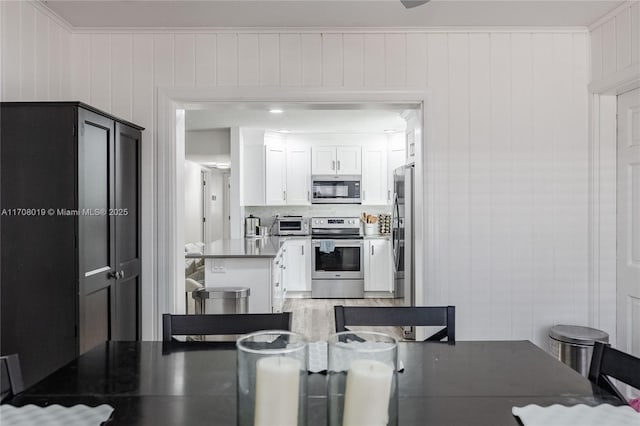 kitchen with white cabinetry, decorative backsplash, stainless steel appliances, and crown molding