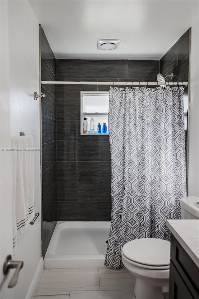 bathroom featuring vanity, a shower with shower curtain, and toilet