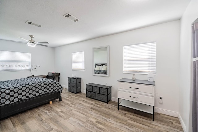 bedroom with ceiling fan, light hardwood / wood-style flooring, and a textured ceiling