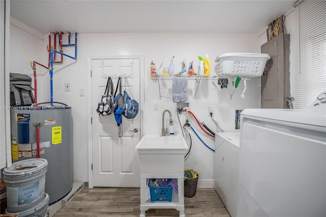 washroom with independent washer and dryer, electric water heater, and light wood-type flooring