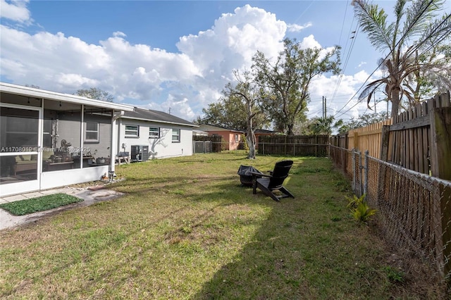 view of yard with central AC and a sunroom