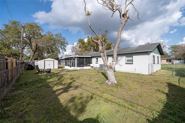 back of house featuring a sunroom, central air condition unit, a shed, and a lawn