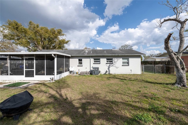 back of house featuring a lawn, a sunroom, and central air condition unit