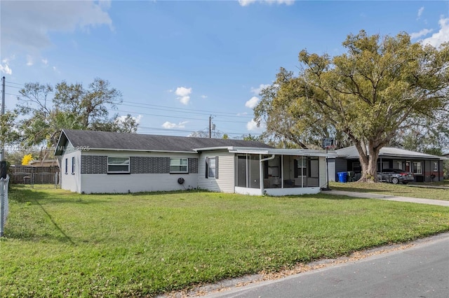 ranch-style home with a sunroom and a front lawn