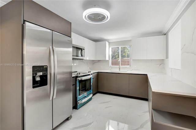 kitchen featuring white cabinetry, sink, stainless steel appliances, tasteful backsplash, and ornamental molding