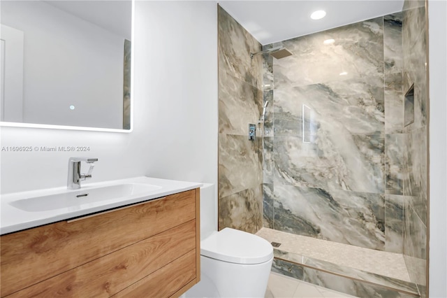 bathroom featuring tiled shower, vanity, and toilet