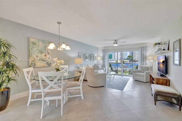 dining space featuring light tile patterned floors, ceiling fan with notable chandelier, and baseboards