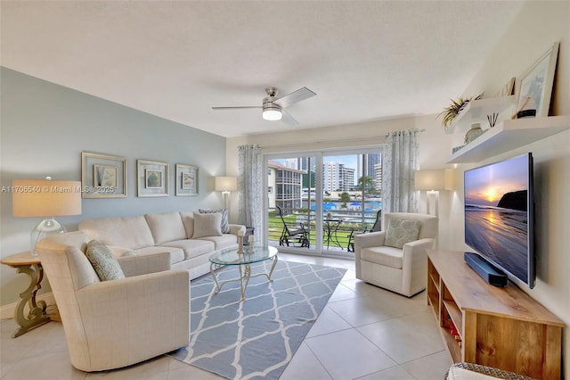 living room featuring a ceiling fan and tile patterned floors