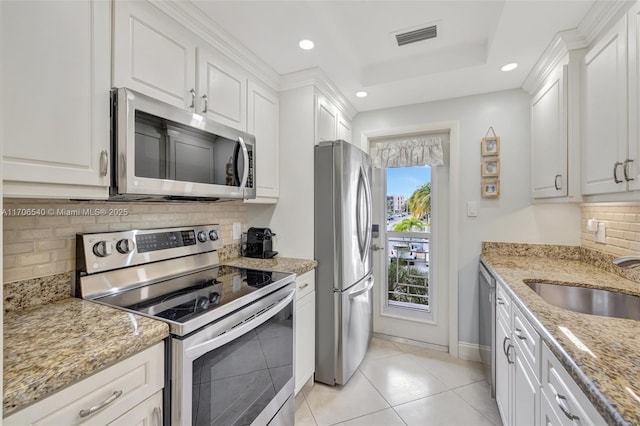 kitchen featuring stainless steel appliances, visible vents, a sink, and white cabinetry