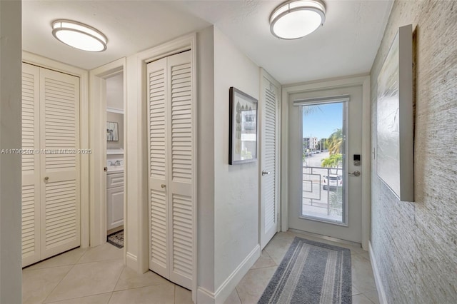 doorway to outside with light tile patterned floors and baseboards