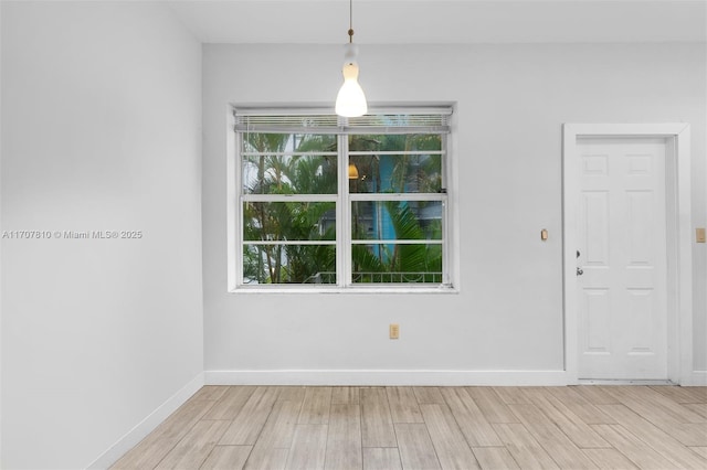 empty room featuring a healthy amount of sunlight and light hardwood / wood-style floors