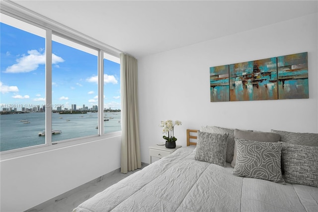 bedroom with a water view and a city view