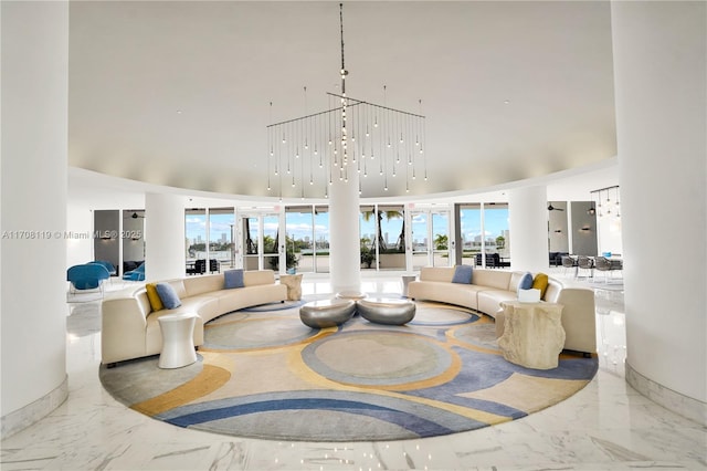 living room with marble finish floor, plenty of natural light, and a high ceiling