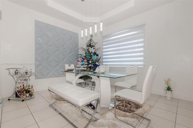 tiled dining room with a raised ceiling