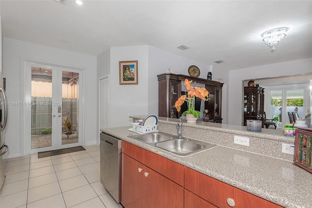 15226 SW 21st Ln, Miami, FL 33185 - kitchen with stainless steel dishwasher, french doors, light countertops, and light tile patterned flooring
