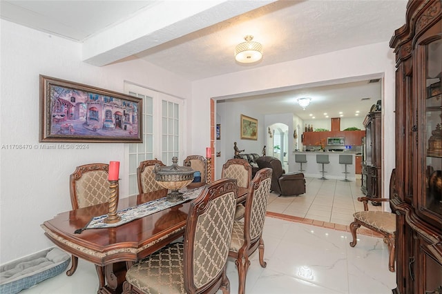 dining area with french doors and a textured ceiling