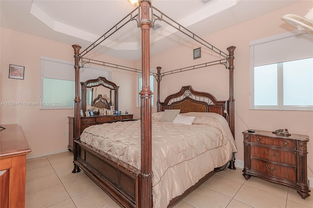 bedroom featuring a raised ceiling and light tile patterned flooring