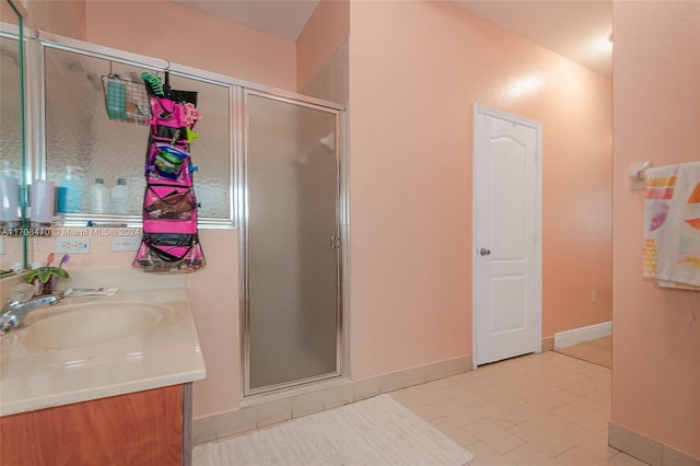 bathroom with tile patterned floors, vanity, and a shower with shower door