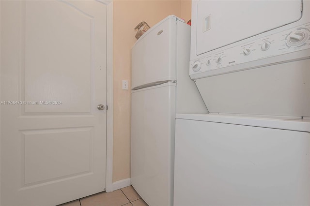 clothes washing area featuring stacked washer and dryer and light tile patterned floors