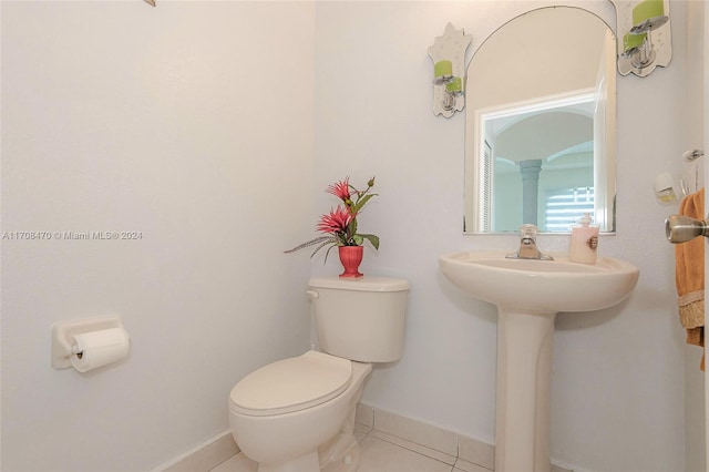 bathroom with tile patterned flooring, toilet, and ornate columns