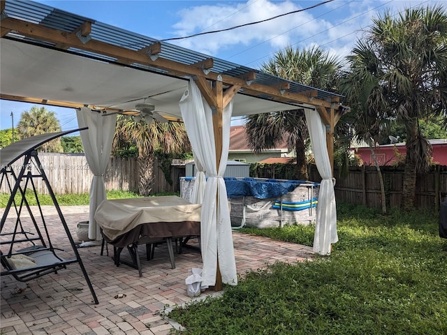 view of patio / terrace with a fenced in pool, area for grilling, a fenced backyard, and a ceiling fan