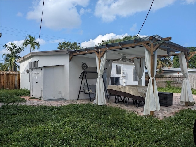 back of property featuring a ceiling fan, fence, a yard, outdoor dining space, and a patio area