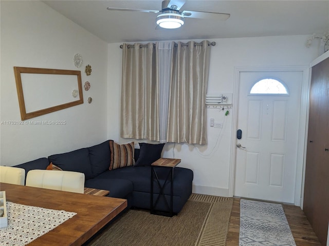 living area with a ceiling fan and wood finished floors