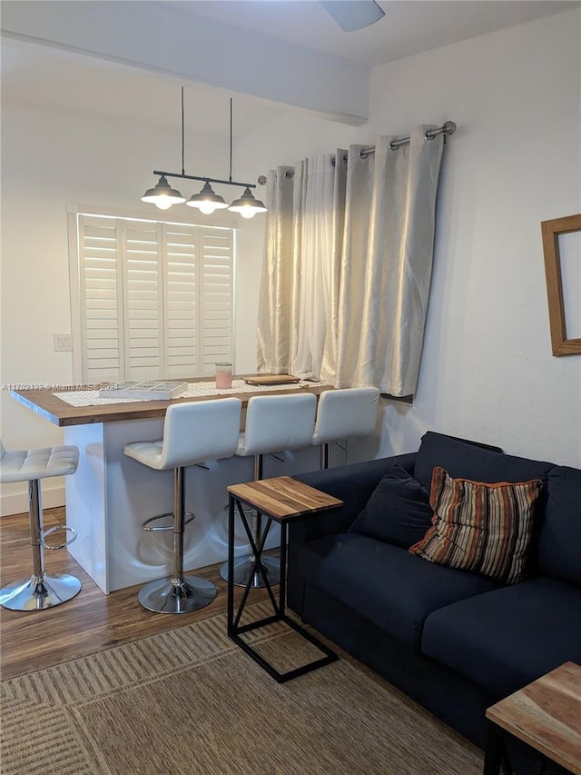 living room featuring beamed ceiling and hardwood / wood-style floors